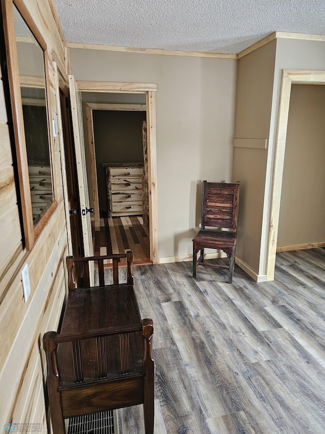 sitting room with ornamental molding, a textured ceiling, and hardwood / wood-style floors