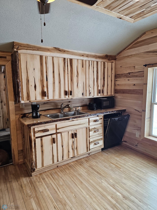 kitchen featuring dishwasher, light hardwood / wood-style floors, vaulted ceiling, and a textured ceiling