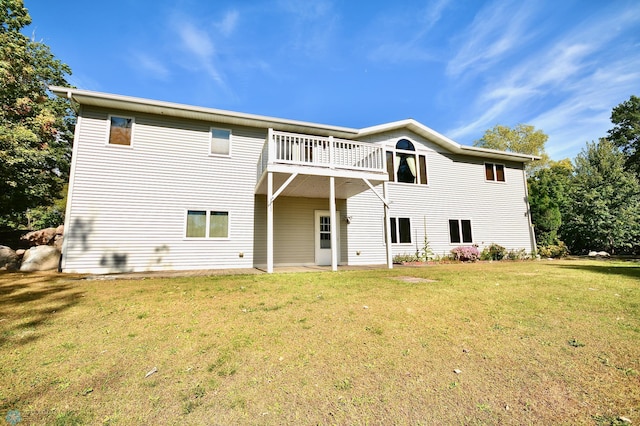 rear view of house with a yard and a balcony