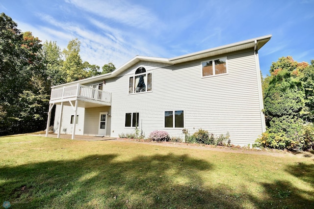 rear view of house featuring a lawn and a patio