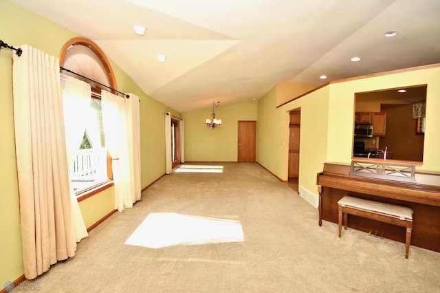 unfurnished room featuring light carpet, an inviting chandelier, and vaulted ceiling