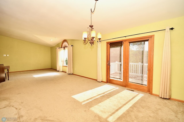 carpeted spare room with a notable chandelier and lofted ceiling