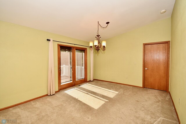 carpeted spare room featuring an inviting chandelier