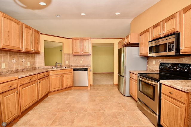 kitchen featuring light brown cabinetry, appliances with stainless steel finishes, sink, and decorative backsplash