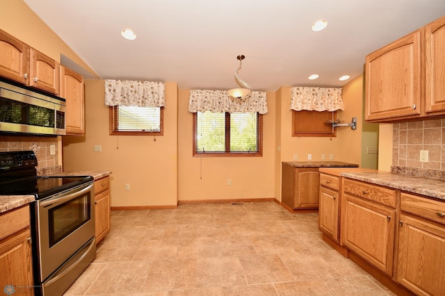 kitchen with light stone counters, decorative light fixtures, stainless steel appliances, and tasteful backsplash