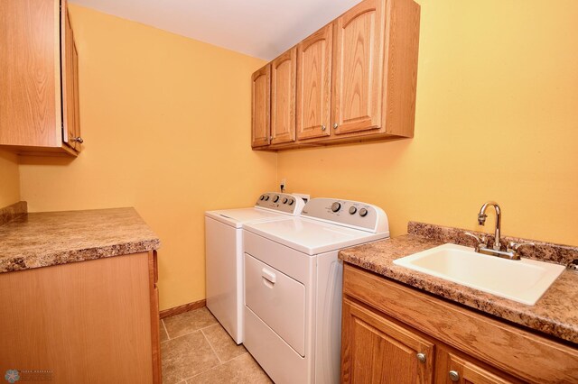 washroom with light tile patterned floors, cabinets, sink, and washing machine and dryer