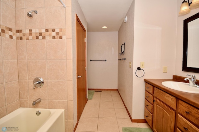 bathroom featuring tile patterned flooring, tiled shower / bath combo, and vanity