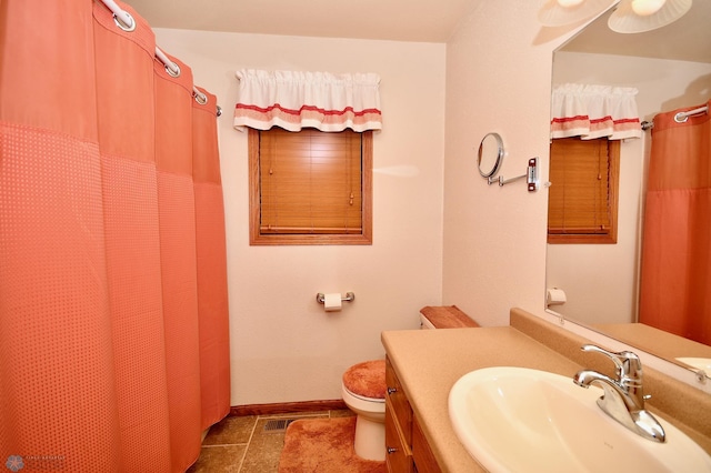 bathroom featuring a shower with shower curtain, vanity, toilet, and tile patterned floors