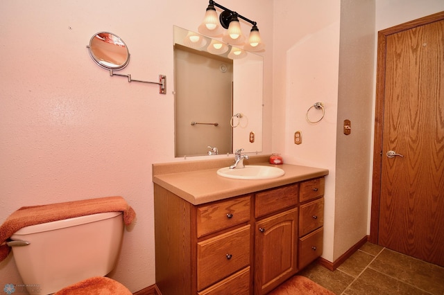 bathroom with tile patterned flooring, vanity, and toilet