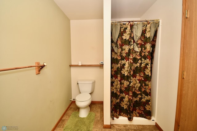 bathroom featuring a shower with shower curtain, toilet, and tile patterned floors