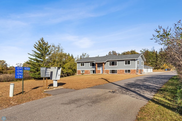 raised ranch with a front yard and a garage