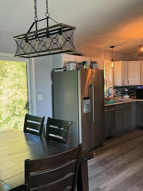 dining area featuring wood-type flooring, a textured ceiling, and sink