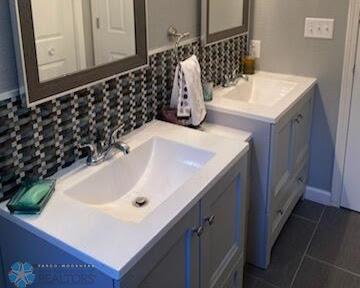 bathroom featuring tile patterned flooring, vanity, and tasteful backsplash