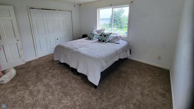 bedroom with dark carpet and a closet