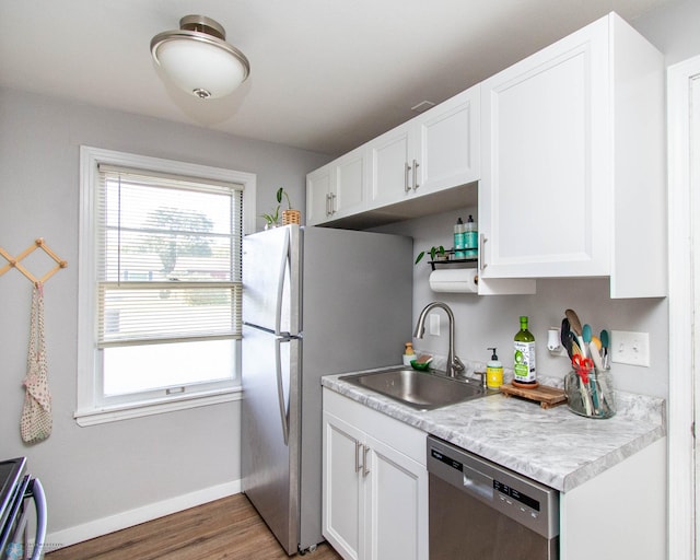 kitchen with appliances with stainless steel finishes, white cabinetry, sink, and dark hardwood / wood-style flooring