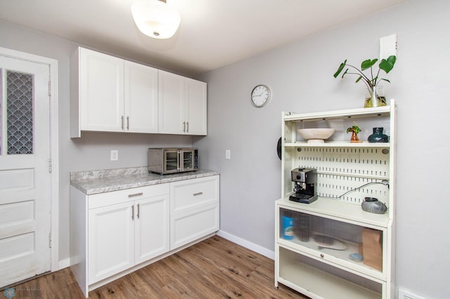 kitchen with white cabinetry and hardwood / wood-style flooring