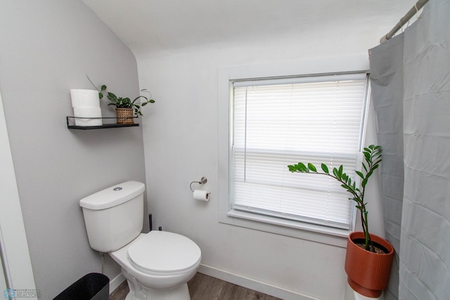 bathroom with hardwood / wood-style flooring, lofted ceiling, toilet, and curtained shower