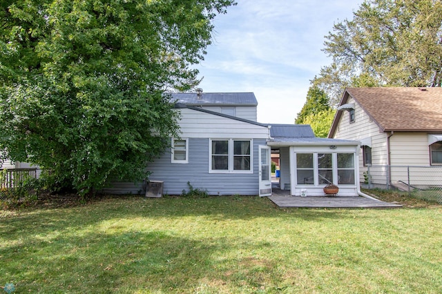 back of house with a lawn and a patio area