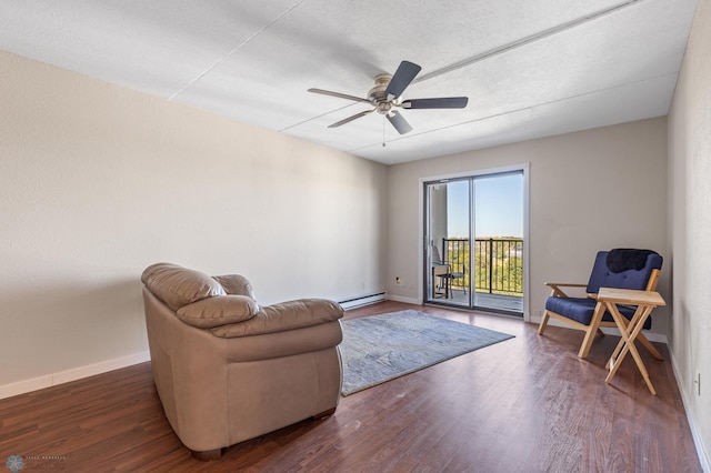 sitting room featuring ceiling fan, baseboard heating, and dark hardwood / wood-style floors