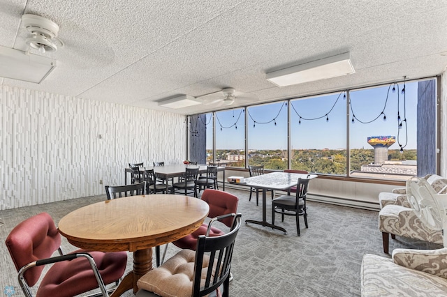 dining space with a textured ceiling, carpet, ceiling fan, and a baseboard radiator