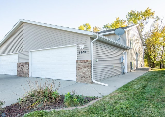 view of side of home with a garage and a lawn