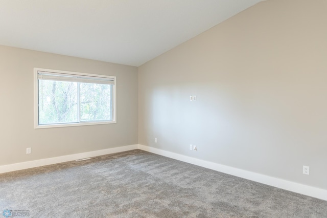 empty room featuring lofted ceiling and light carpet