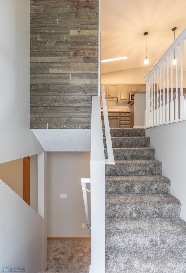 staircase featuring carpet flooring and vaulted ceiling