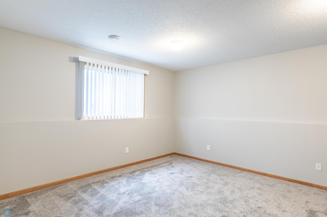 spare room with a textured ceiling and carpet flooring