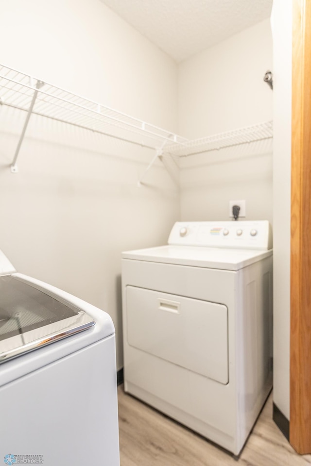 laundry area featuring light hardwood / wood-style floors and washer and dryer