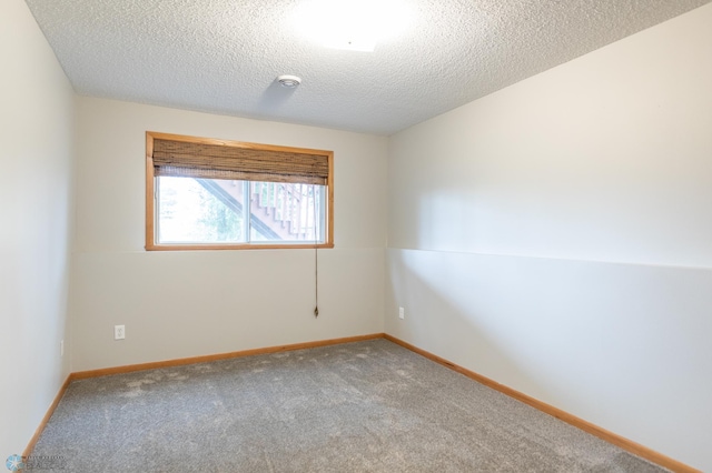 spare room featuring a textured ceiling and carpet flooring