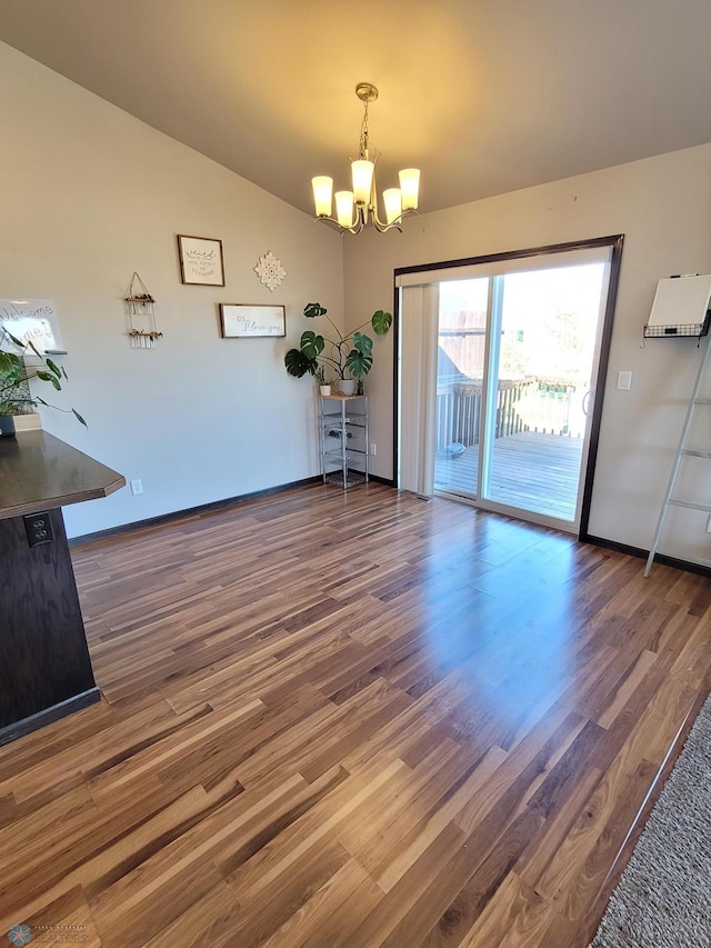 unfurnished dining area with an inviting chandelier, vaulted ceiling, and dark hardwood / wood-style floors