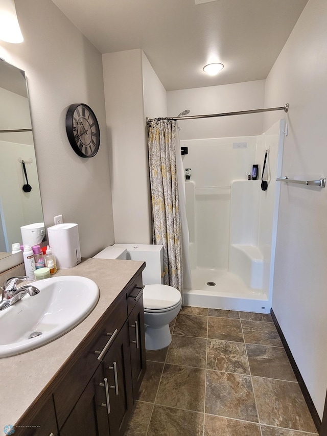 bathroom with walk in shower, vanity, and toilet