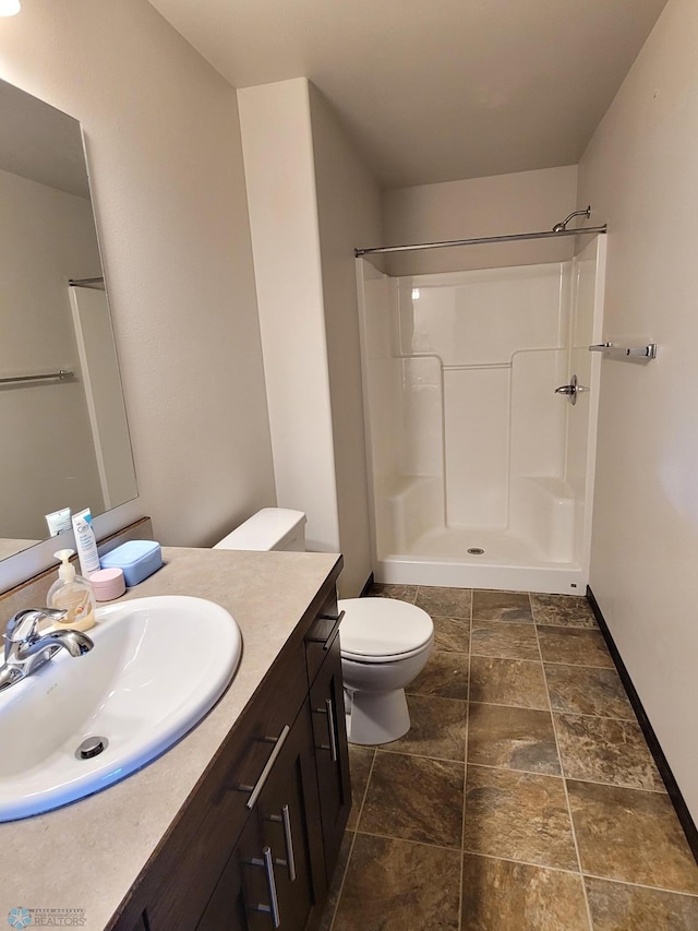 bathroom with vanity, a shower, and toilet