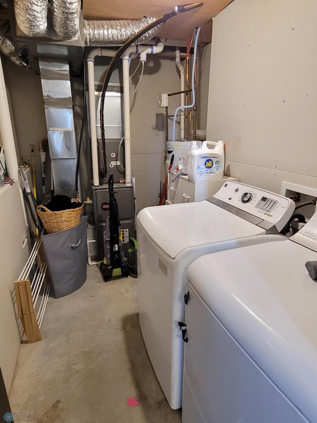 clothes washing area with water heater and washing machine and dryer