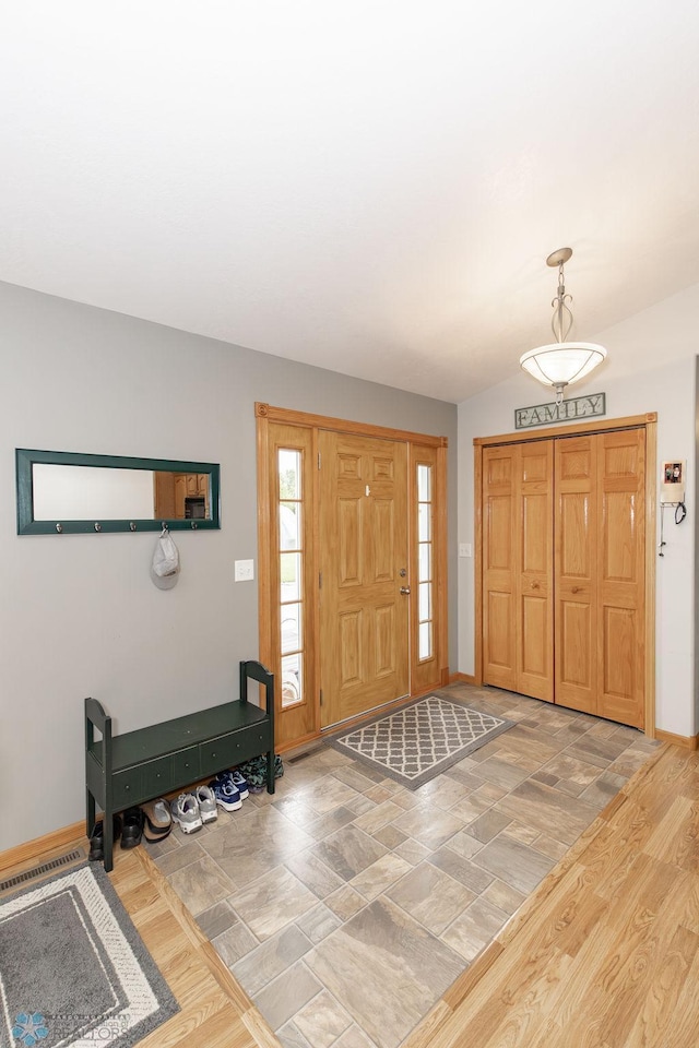 entryway with vaulted ceiling and hardwood / wood-style flooring