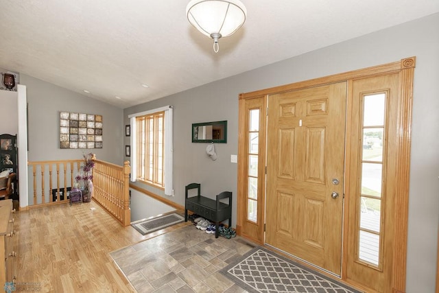 entrance foyer featuring a wealth of natural light, vaulted ceiling, and light wood-type flooring