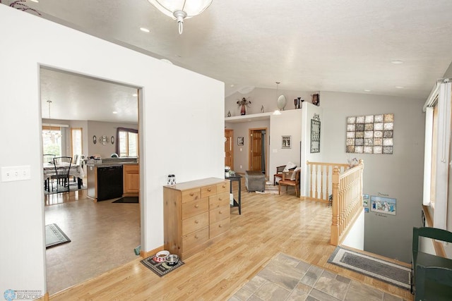 hall featuring lofted ceiling and light hardwood / wood-style floors