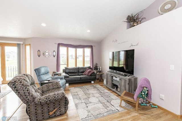 living room featuring light wood-type flooring, a healthy amount of sunlight, and high vaulted ceiling