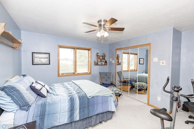 carpeted bedroom with multiple windows, ceiling fan, and a closet