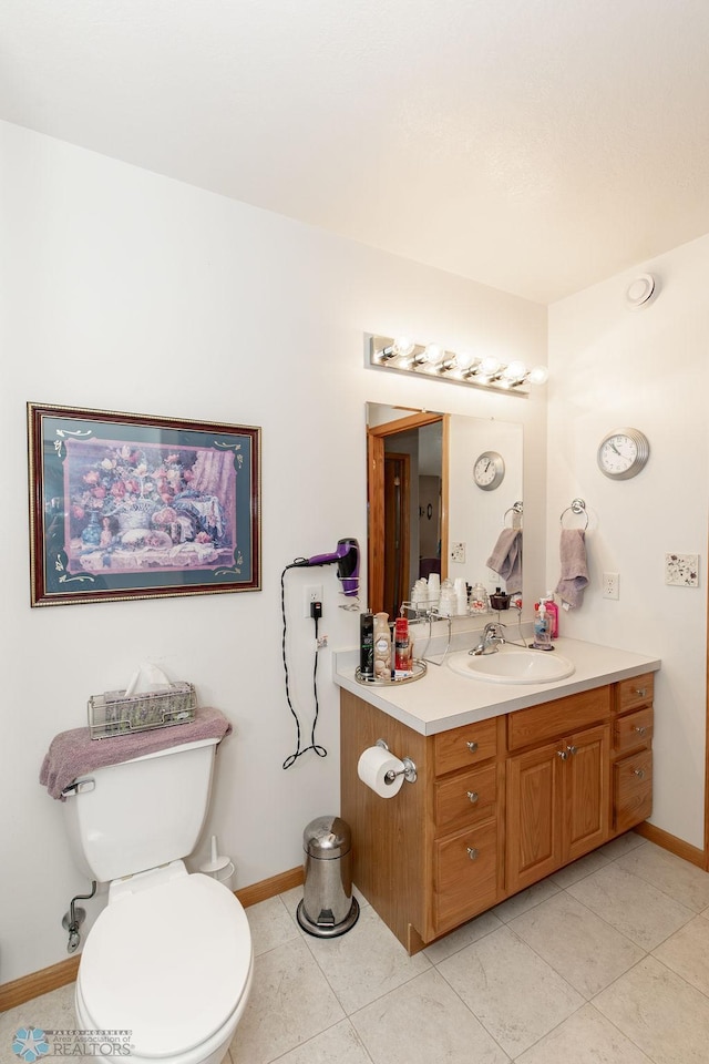 bathroom featuring tile patterned flooring, vanity, and toilet