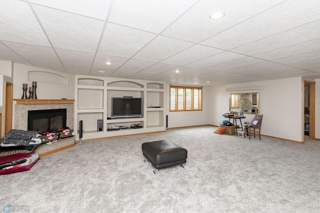 carpeted living room featuring a paneled ceiling and a tile fireplace