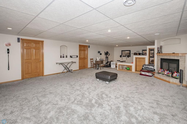 recreation room featuring carpet, a fireplace, and a drop ceiling