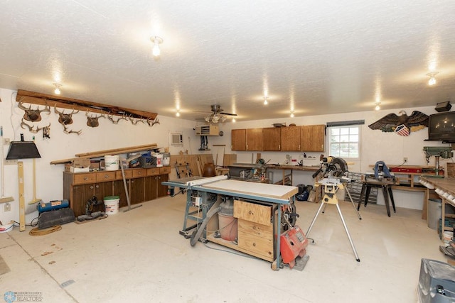 misc room with a workshop area, ceiling fan, and a textured ceiling