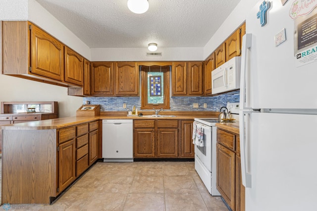 kitchen featuring white appliances, a textured ceiling, sink, and backsplash