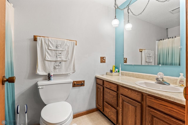 bathroom featuring a textured ceiling, tile patterned flooring, vanity, and toilet