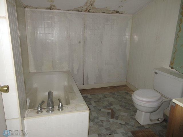 bathroom featuring vanity, a washtub, and toilet