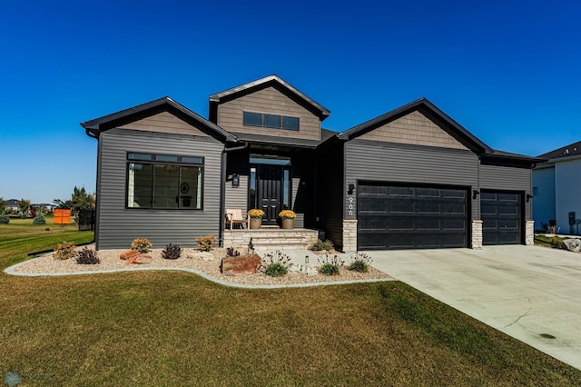 craftsman inspired home featuring a garage and a front lawn