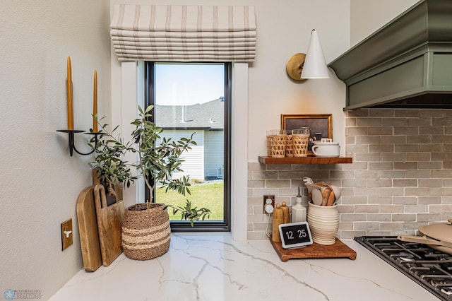 kitchen with light stone countertops, plenty of natural light, green cabinets, and cooktop