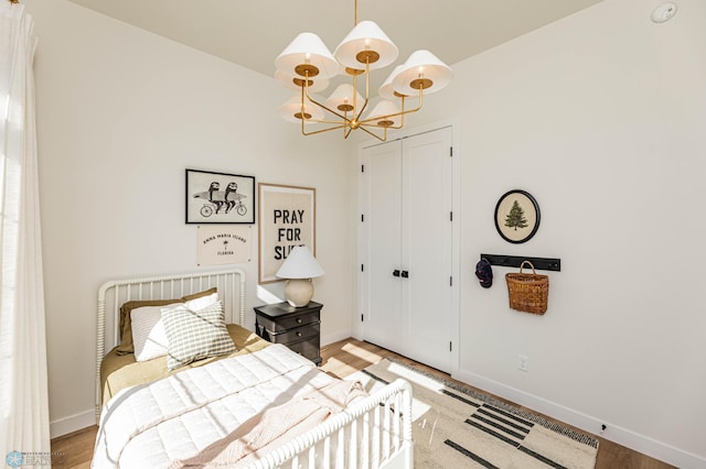 bedroom with an inviting chandelier and light hardwood / wood-style floors