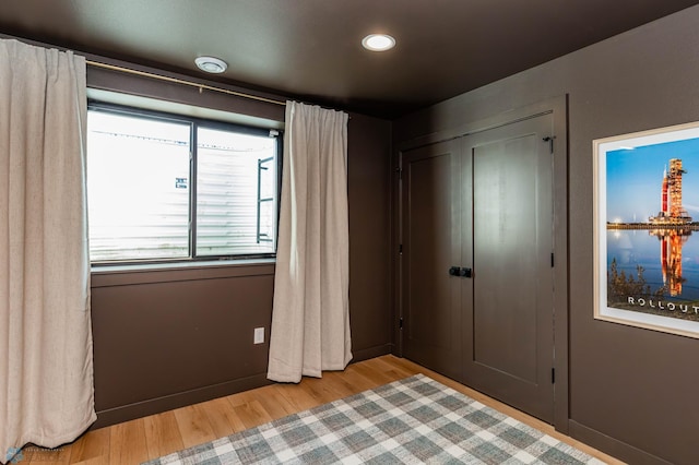 unfurnished bedroom with light wood-type flooring and a closet